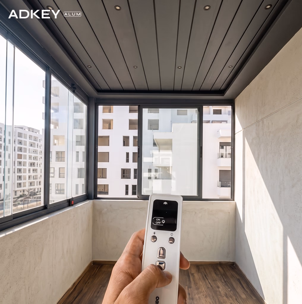 Véranda de balcon fermée en aluminium anthracite avec toiture bioclimatique motorisée pilotée par télécommande dans un appartement à Tanger — Aluminium Tanger